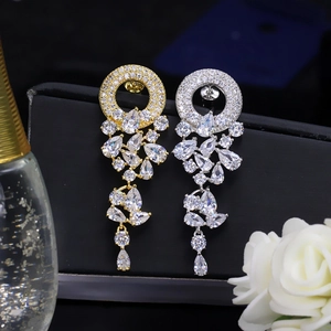 Macro shot of gold and silver drop earrings with sparkling AAA cubic zirconia fringe details