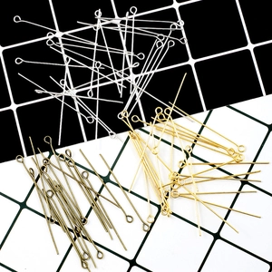 Macro view of gold, silver, and bronze eye pins for DIY jewelry making and beading