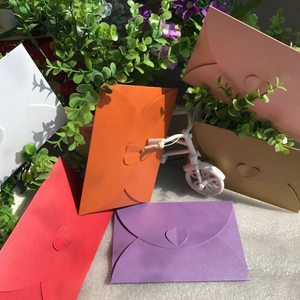 Macro detail of multi-colored envelopes with heart-shaped clasps and pearlescent finish