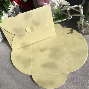 Detailed view of pearlescent heart-shaped buckle envelope in cream color for cards