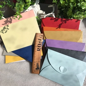 Detail of colorful pearlescent envelopes with heart-shaped clasps and paper texture