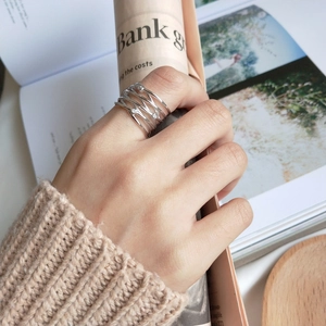 Detail of layered S925 silver wire ring with sparkling zircons on a model's hand