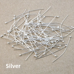 Macro shot of silver-plated metal ball head pins for DIY jewelry making on kraft paper