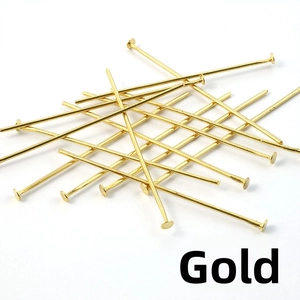 Detailed view of polished golden T-pins and flat head pins for DIY jewelry making