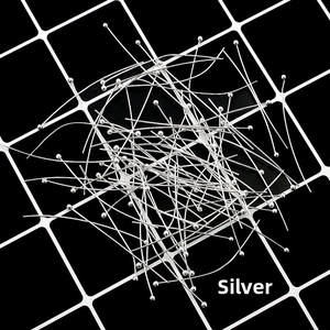 Macro shot of silver ball head pins for DIY jewelry making displayed on a black grid background