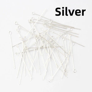 Close-up of bulk silver-plated metal eye pins for DIY handmade jewelry and beading crafts