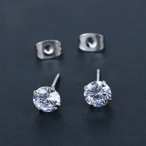 Macro detail of silver stainless steel stud earrings with four-claw round zircon stones