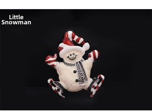 Detail of cute little snowman brooch with red striped hat and glittering white texture