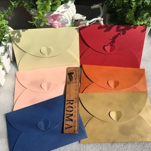 Various colored cardstock envelopes with heart-shaped clasps and measurement scale