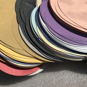 Close-up of colorful circular pearlescent paper envelopes with heart-shaped closures