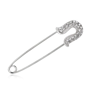 Detail showing a silver brooch pin with shimmering crystals on a white reflective base