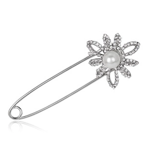 Close-up of silver flower brooch with sparkling rhinestones and a central white pearl