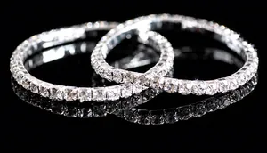 Close-up of dual silver stretch bracelets with pavé rhinestones on black reflection