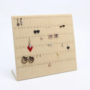 L-shaped beige linen earring display board with multiple holes for jewelry storage