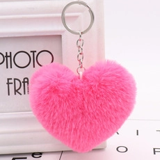 Close-up of pink heart-shaped plush keychain with soft fur and silver metal ring