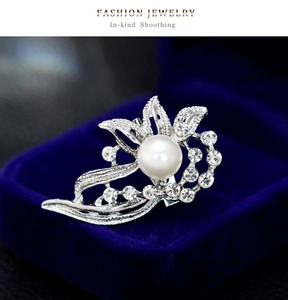 Detailed close-up of elegant flower brooch with pearls and rhinestones on velvet