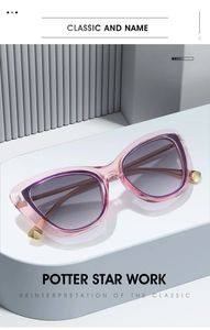 Detail view of pink cat eye sunglasses with metal tips on a minimalist geometric pedestal