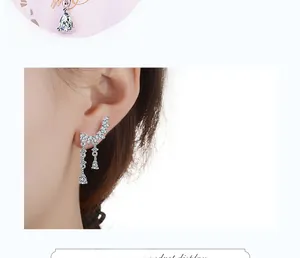 Detail of silver wing stud earring with sparkling long tassels and pear cut zircon drops