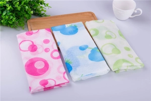 Detailed texture of pink blue and green nylon exfoliating bath towels on wood tray