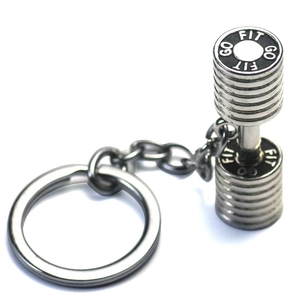Macro shot of silver metal dumbbell keychain with GO FIT engraving on a white background