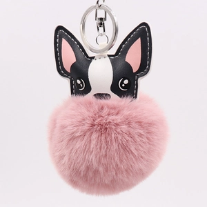 Detail of cute tricolor PU leather puppy charm with a large pink fluffy pompom keychain