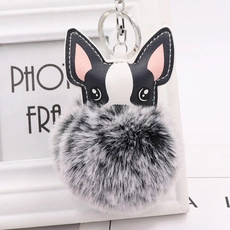 Detail of cartoon bulldog faux fur keychain with black and white leather stitching