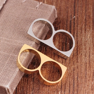 Dual-finger minimalist metal ring in gold and silver colors on rustic background