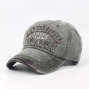 Close-up of vintage washed cotton baseball cap with leather brim edge and embroidery