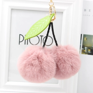 Pink cherry plush keychain with soft faux fur balls and green leaf on gold ring hook