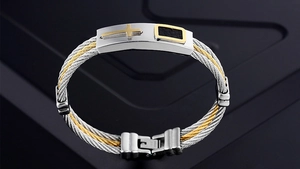 Macro view of men's twisted cable bracelet with a golden cross and black textured inlay