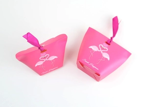 Detailed view of pink flamingo candy box with sweet happiness text and red ribbon