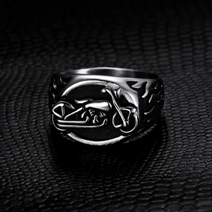 Vintage stainless steel motorcycle flame ring for men on black textured background
