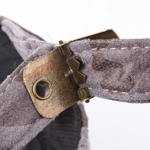 Adjustable brass buckle and vintage camouflage strap detail on back of baseball cap