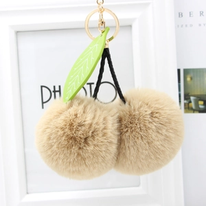 Faux rabbit fur cherry keychain in khaki with gold hardware and green leaf accent