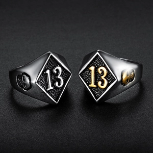 Makroaufnahme von Punk-Biker-Ring mit Zahl 13 und Totenkopf-Relief in Gold und Silber