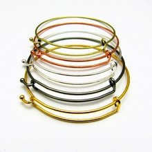 Detail view of 5 adjustable wire bracelets in gold, silver, bronze, and black finishes