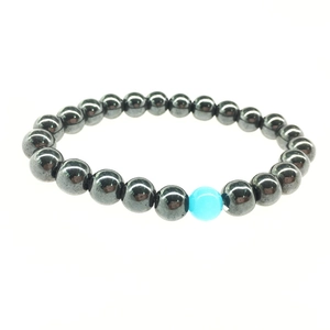 Polished grey hematite beaded bracelet with a blue cat eye stone on white background