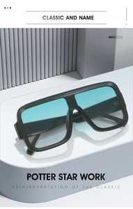 Detail of oversized square sunglasses featuring black thick frame and light blue lenses