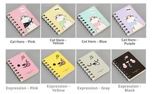 Macro detail of portable A7 spiral notebooks featuring cute cartoon cat and emoji designs