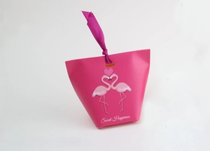 Detailed view of flamingo candy box with pink ribbon handle and Sweet Happiness text