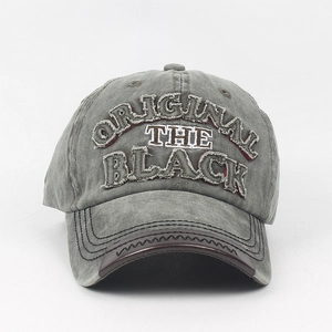 Detail of gray washed baseball cap with embroidered logo and brown leather brim trim