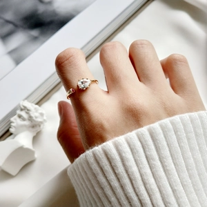 Detailed close-up of a pear-shaped zircon adjustable gold ring on a woman's hand