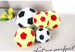 Detail of plush football pillows in various sizes and colors displayed on a cozy sofa