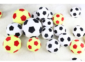 Detailed macro view of plush soccer pillows in various sizes and dual-color stitching