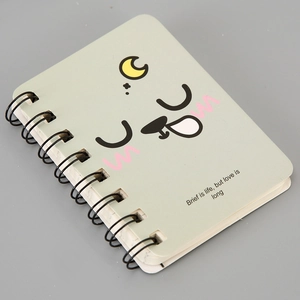 Macro detail of the green A7 spiral notebook featuring a cute cartoon smiley face