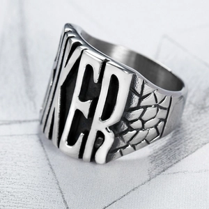 Macro view of stainless steel Biker ring with bold letter relief and scale texture