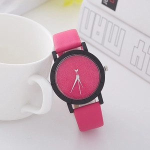 Detail of rose red leather strap watch with purple glitter dial and moon hands on a desk