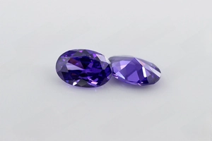 Vue macro de deux zircons violets ovales facettés montrant l'éclat et la coupe précise