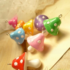 Macro shot of colorful resin mushroom charms with metal rings for DIY handmade jewelry