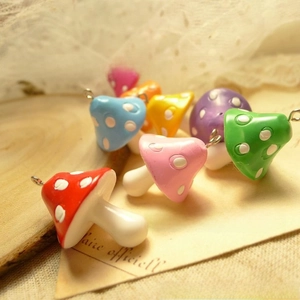 Detailed view of colorful resin mushroom pendants with white polka dots and metal hooks